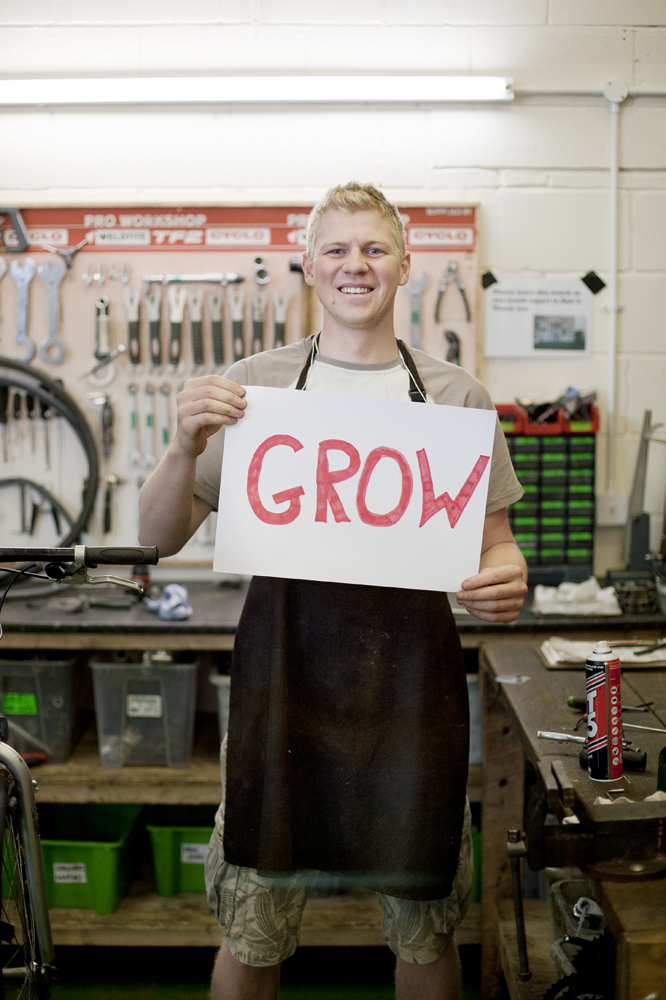 Young person holding up a sign that says 'grow'
