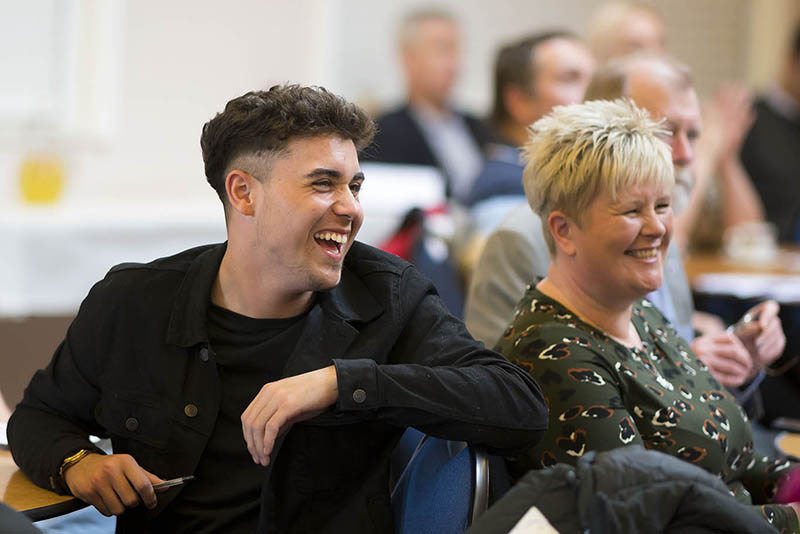 Two people looking on and smiling