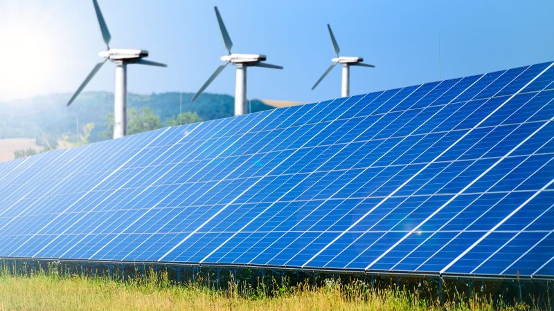 Wind turbines and solar panels in a countryside area.